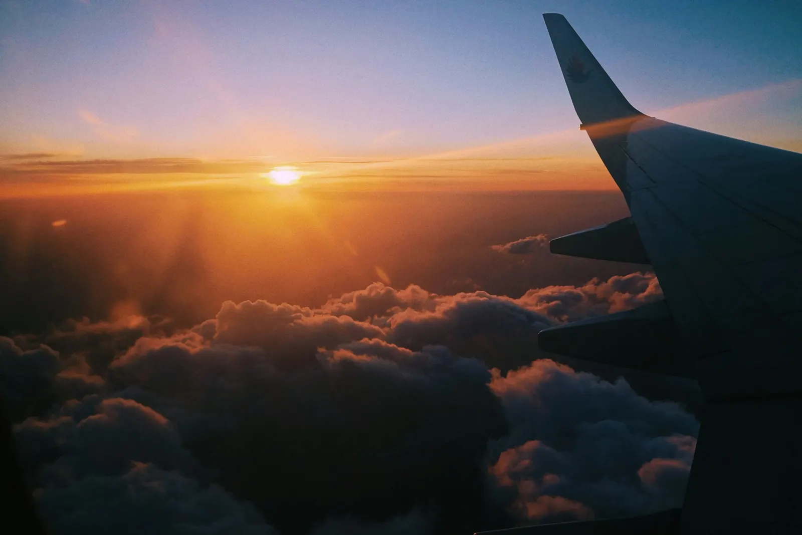 Ala de avión sobre las nubes al atardecer