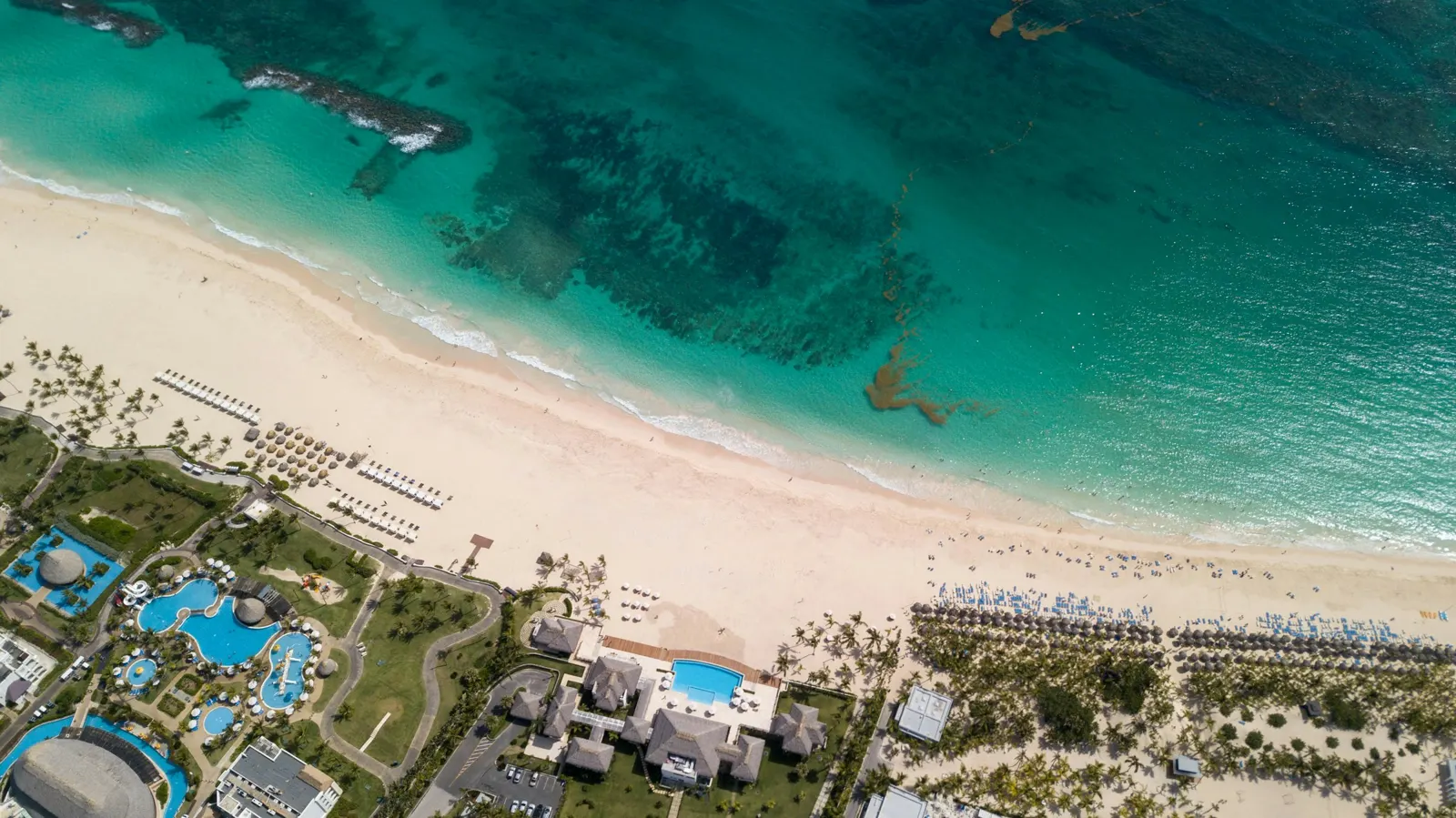 Playa de arena blanca y mar turquesa vista desde el aire